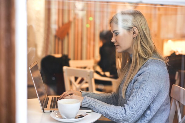 serious-young-woman-using-netbook-while-having-hot-drink-in-3766227.jpg